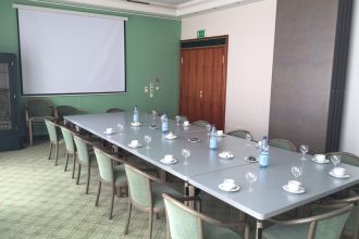 Seminarraum: großer Tisch mit Tafel an der Wand