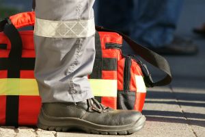 Symbolbild: Bein eines Notfallsanitäters steht vor einer Notfallsanitätertasche